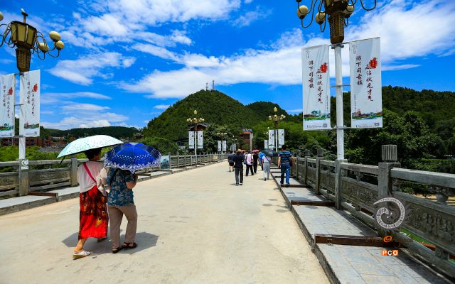 游客经过下司古镇大桥