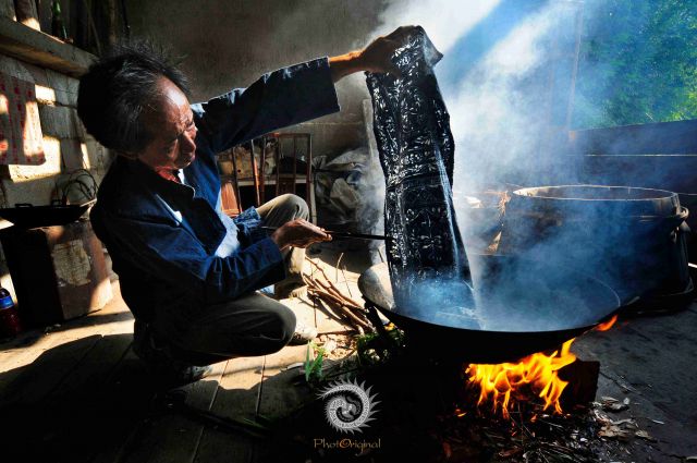 杨光成在用沸水脱去画布上油脂